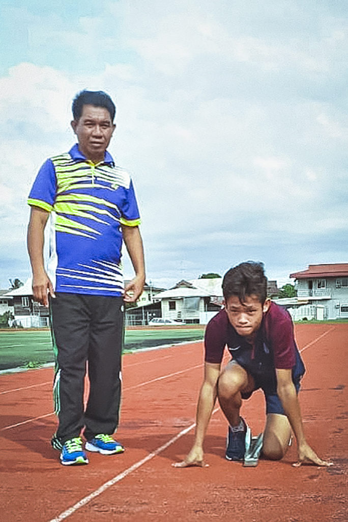Azrul, an athlete with intellectual disability from Brunei, with his coach, Suhaili, on the tracks.