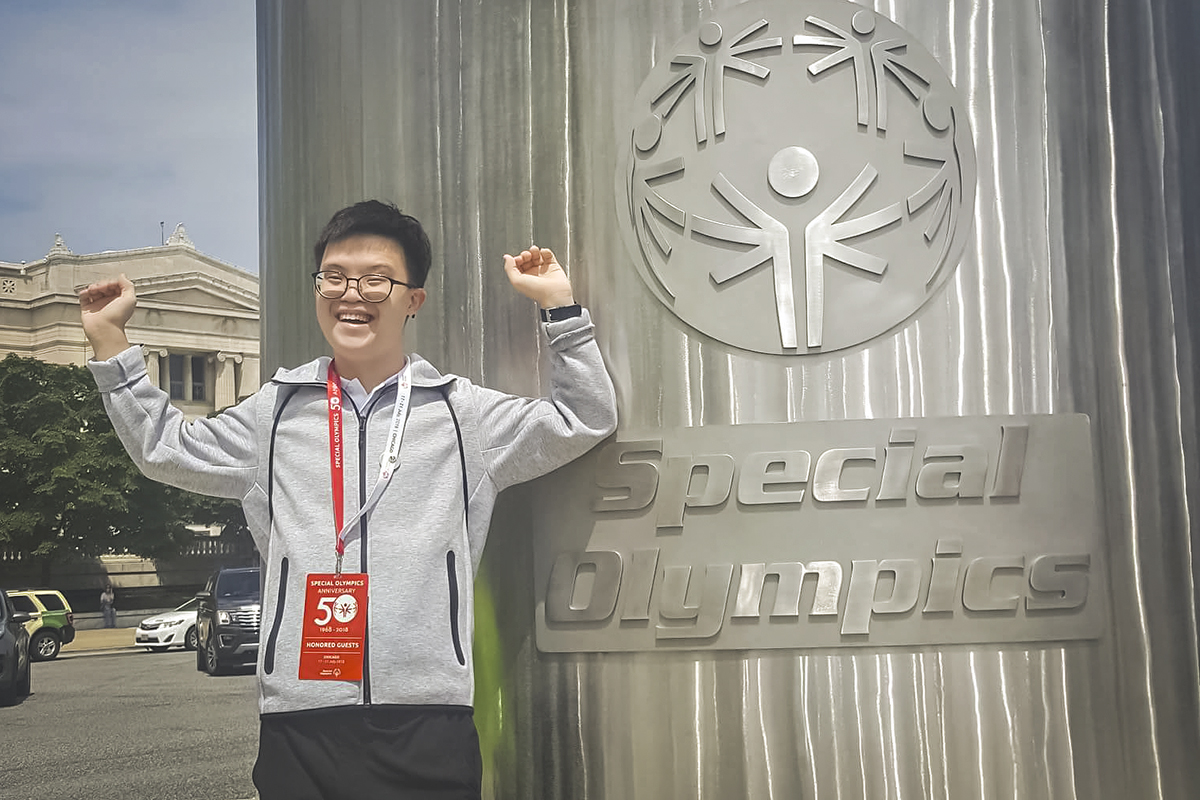 Johannes Cheong, Special Olympic Asia Pacific athlete, posing next to a Special Olympics logo.